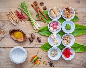 Various of thai food cooking ingredients for spice red curry paste ingredient of thai popular food on galanga leaf background. Spices ingredients chili ,pepper, nutmeg, garlic and Kaffir lime leaves.